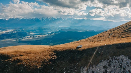 Portable refrigerator secured in an overlanding vehicle beside organized camping equipment