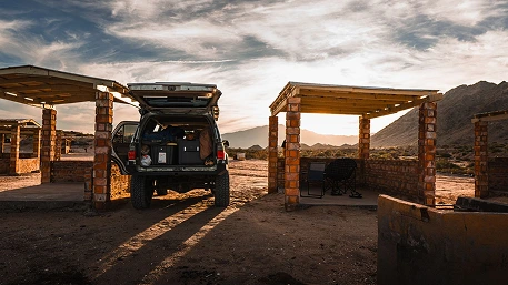 Portable fridge restrained with straps to cargo anchors in the rear of an SUV