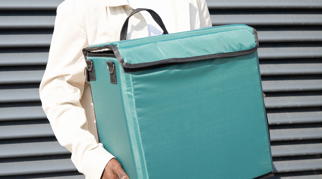 Portable fridge accessories arranged beside a vehicle power socket, thermometer, extension cable, and fitted cover